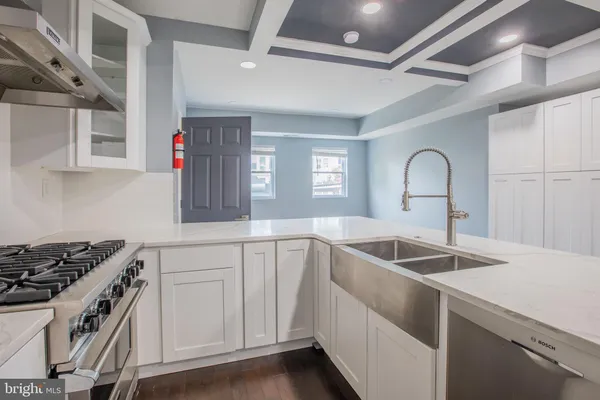 a kitchen with granite countertop a sink stainless steel appliances and cabinets