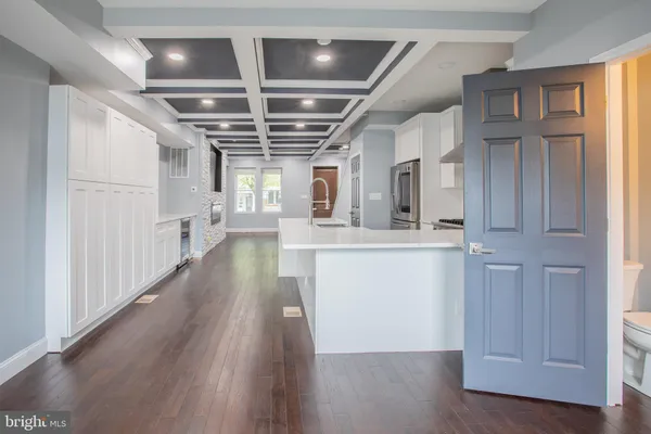 a kitchen with stainless steel appliances wooden floors and view living room