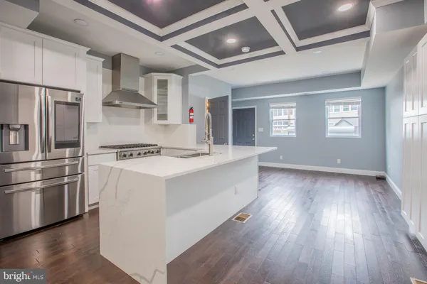 a kitchen with stainless steel appliances a white stove top oven a refrigerator and a window