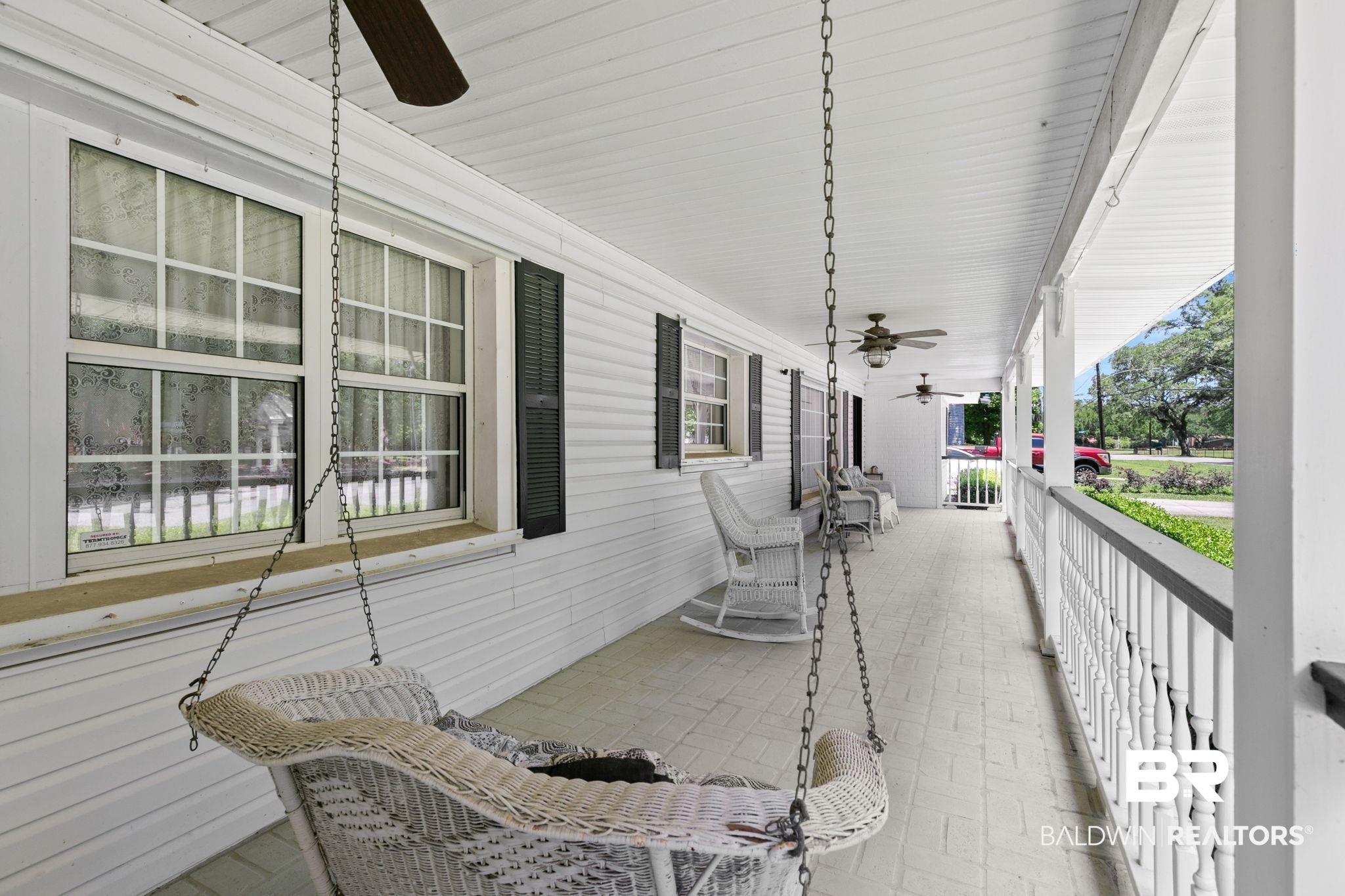 927 Cleveland Road Saraland, AL 36571 - Photo 52 of 80 Expansive covered porch featuring a painted wood-finish ceiling, multiple ceiling fans, white siding, and decorative balusters