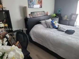 a bedroom with a bed and a flat tv screen on the dresser
