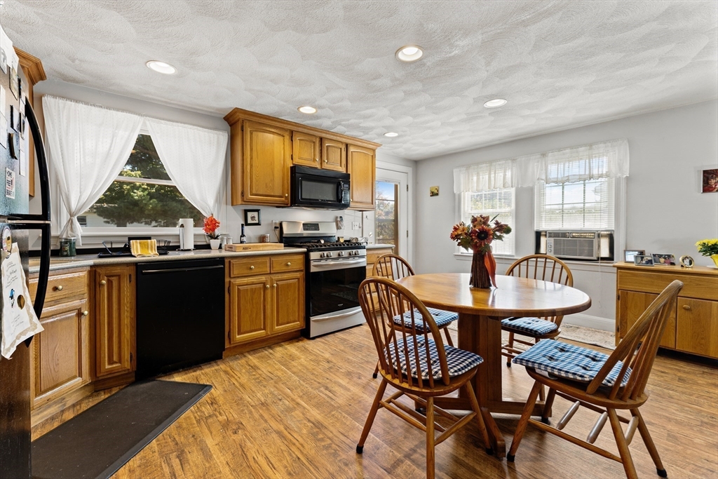 85 Oak Street Stoneham, MA 02180 - Photo 11 of 35 a kitchen with stainless steel appliances a table and chairs in it