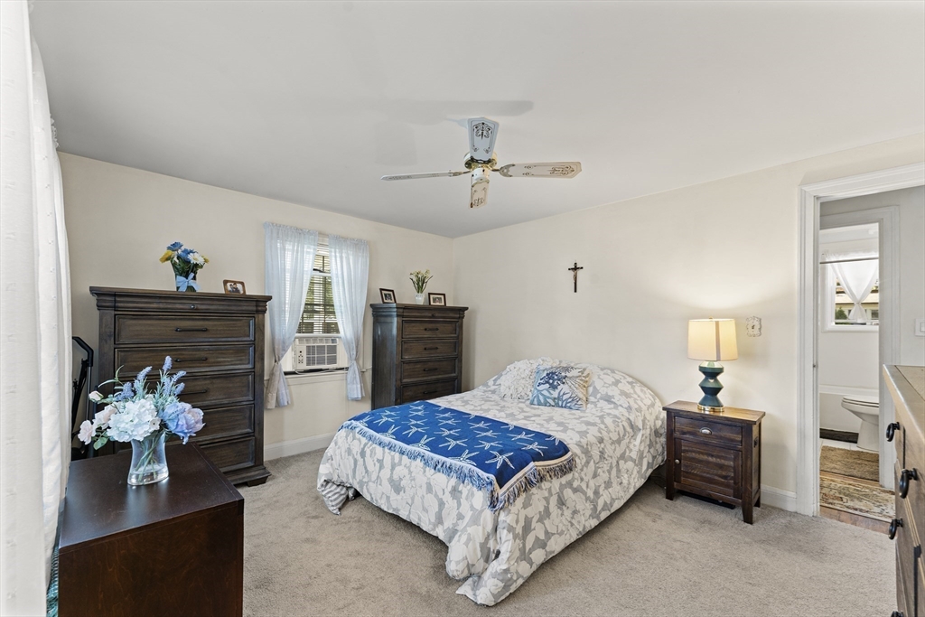 85 Oak Street Stoneham, MA 02180 - Photo 17 of 35 a bedroom with a bed potted plant on the dresser and a chandelier
