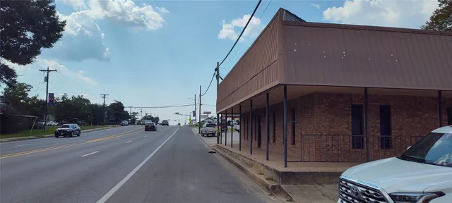 a view of a street with cars parked on the road