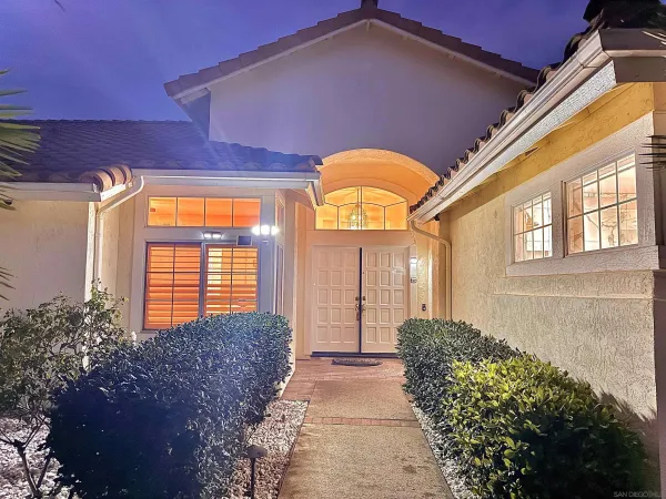 a view of a house with large windows and a yard