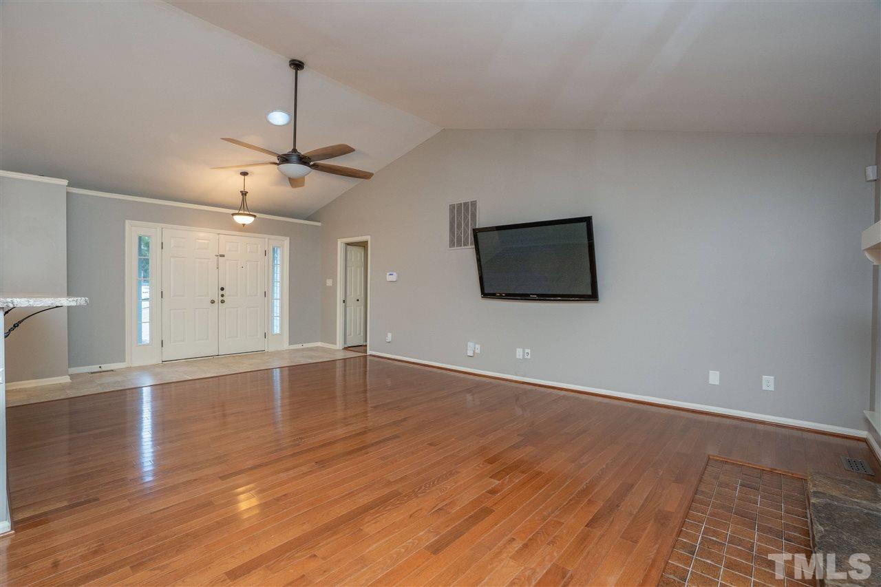 5400 Chilham Place Raleigh, NC 27612 - Photo 3 of 25 a view of an empty room with wooden floor and a ceiling fan