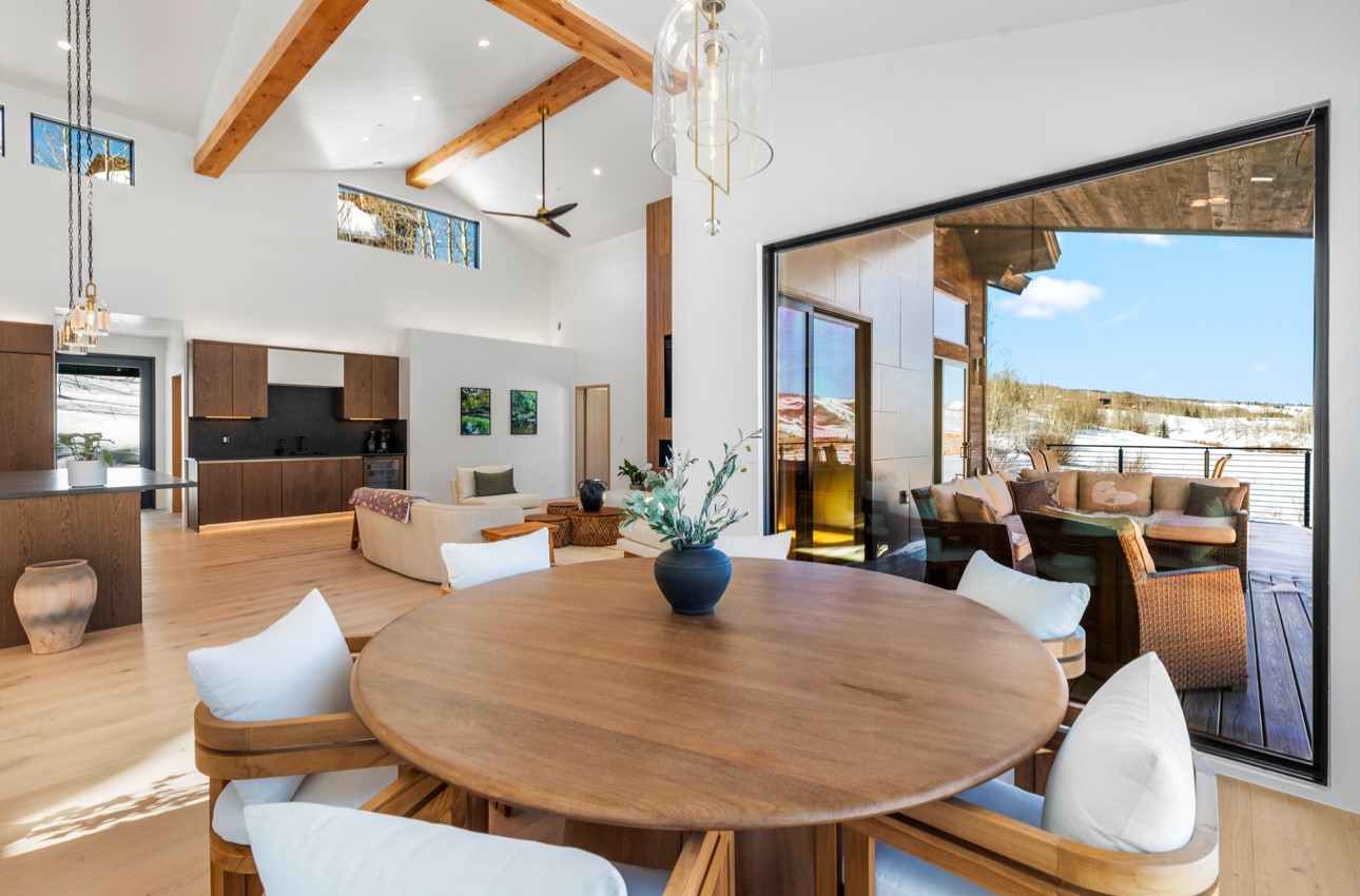 Dining space with beamed ceiling, ceiling fan, light wood-type flooring, and sink