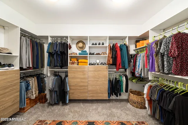 a view of walk in closet with clothes and shoes