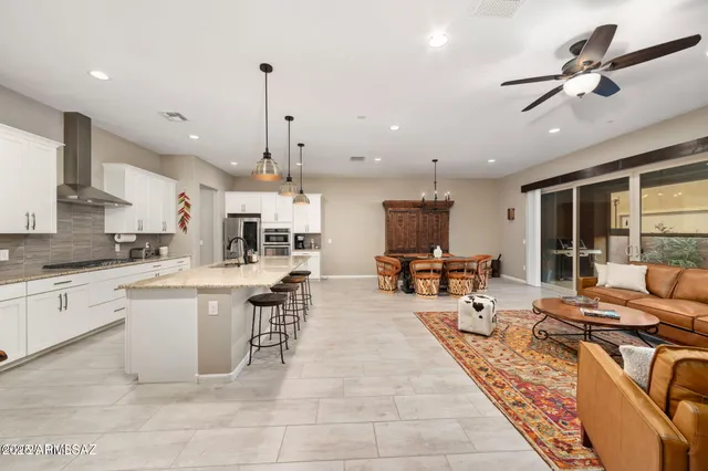 a large kitchen with a table chairs stainless steel appliances and cabinets