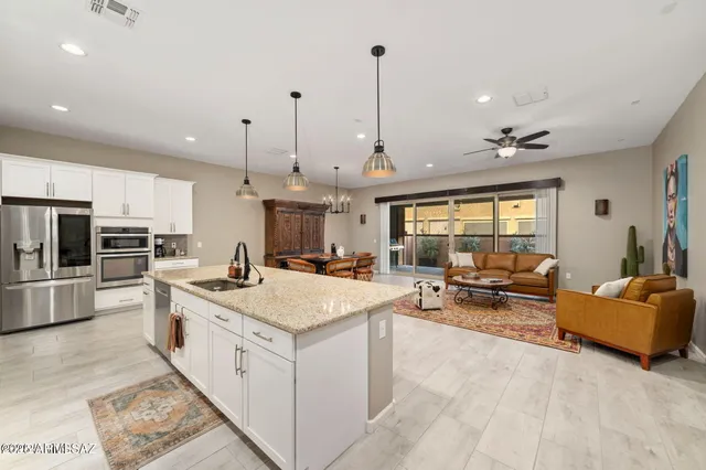 a large kitchen with stainless steel appliances kitchen island granite countertop a lot of cabinets and couches