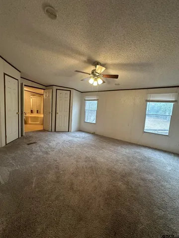 a view of an empty room with a chandelier fan