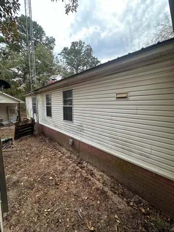 a view of house with outdoor space and trees