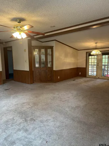 en empty room with windows and ceiling fan