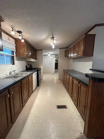 a kitchen with stainless steel appliances granite countertop a sink stove and cabinets