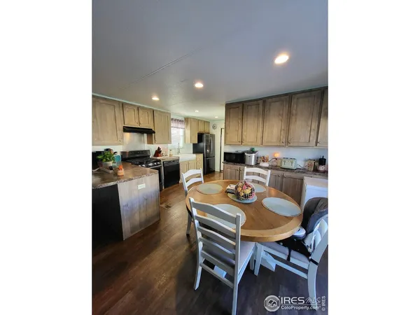 a kitchen with a dining table chairs and refrigerator