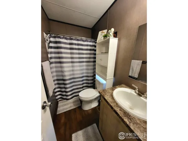 a bathroom with a granite countertop toilet sink and mirror