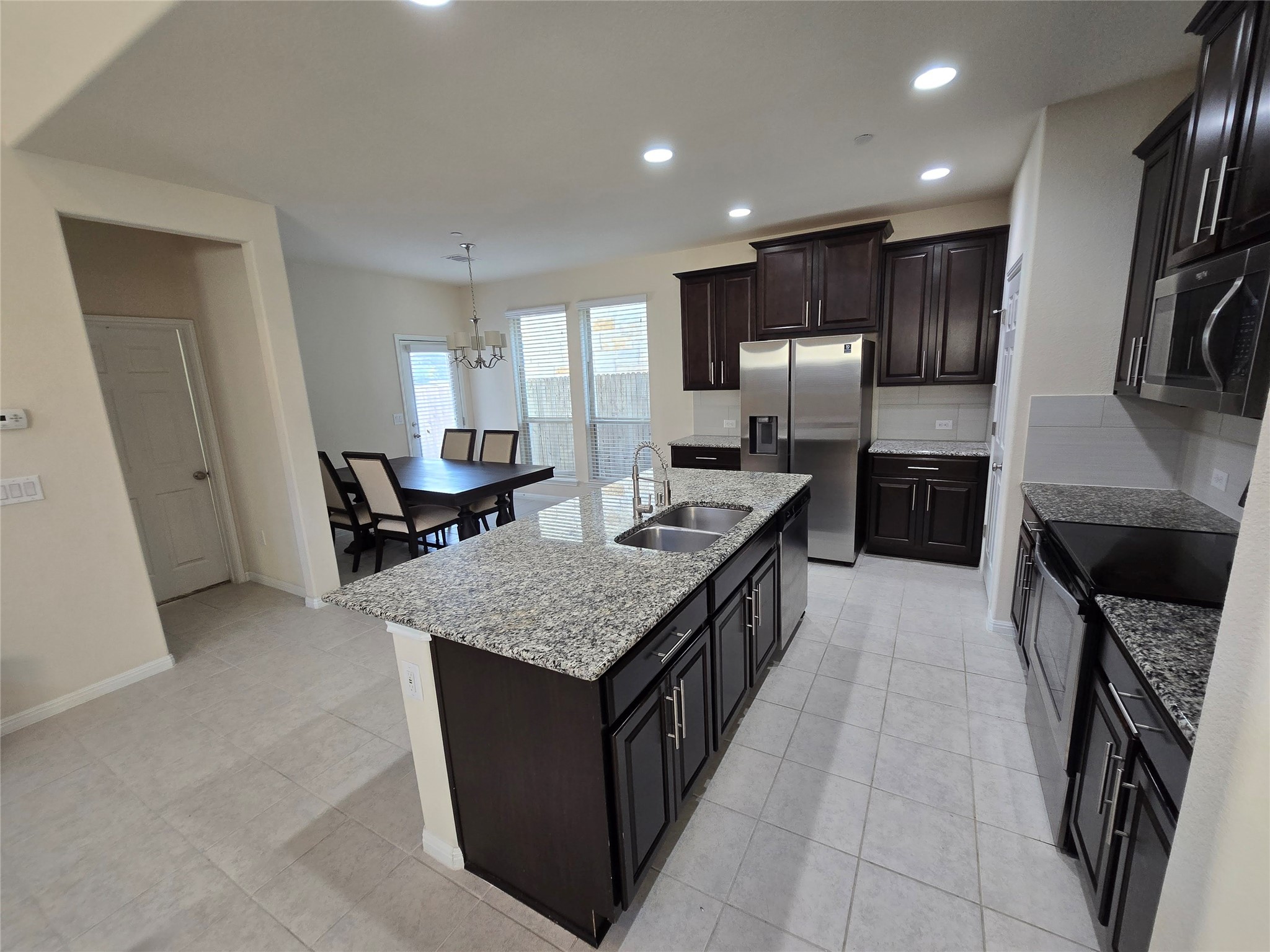 3240 East Whitestone Boulevard, Unit 49 Cedar Park, TX 78613 - Photo 7 of 33 a large kitchen with stainless steel appliances kitchen island granite countertop a large counter top a sink a stove and a refrigerator