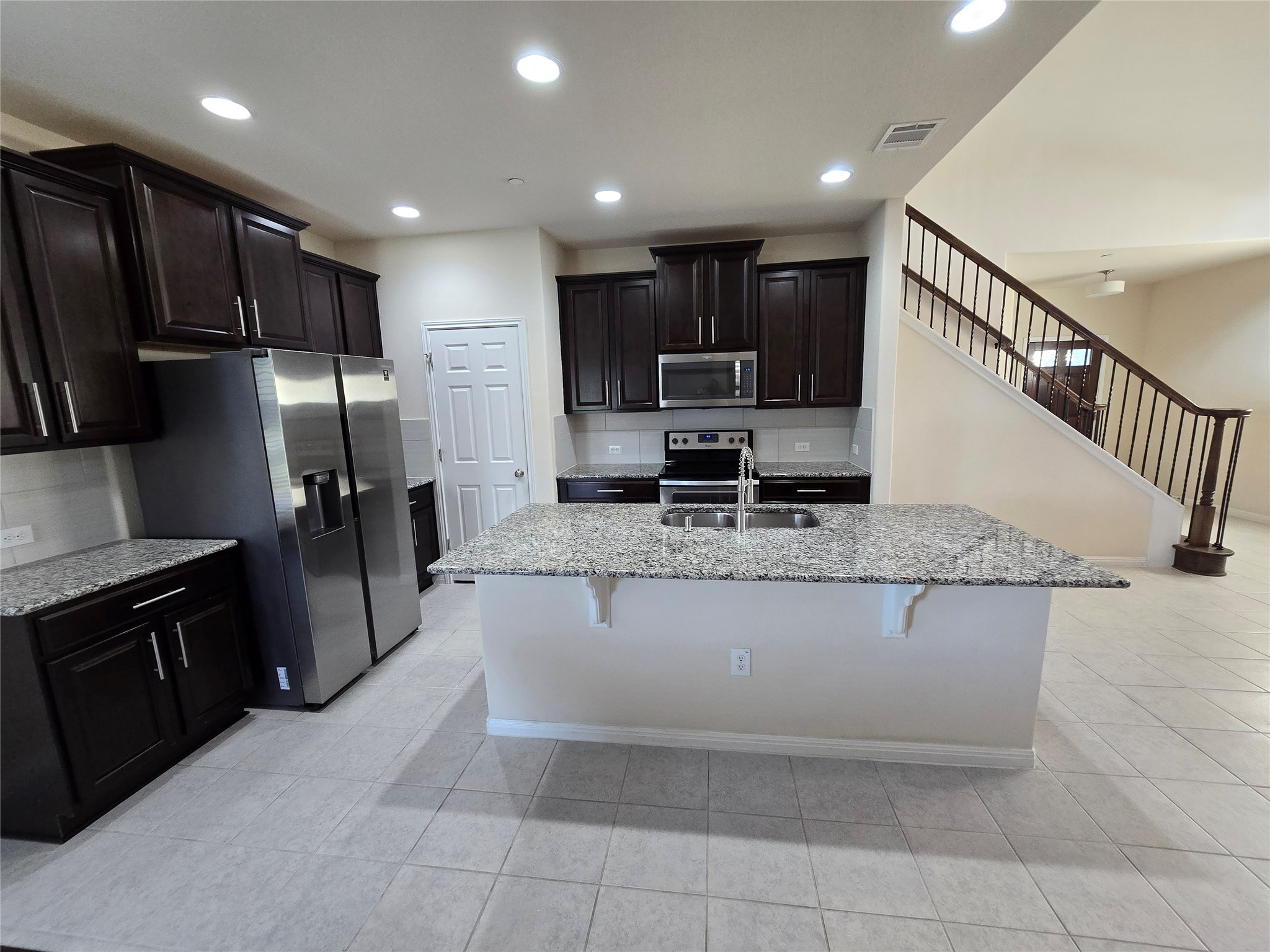 3240 East Whitestone Boulevard, Unit 49 Cedar Park, TX 78613 - Photo 8 of 33 a kitchen with stainless steel appliances granite countertop a refrigerator a stove a sink and a microwave