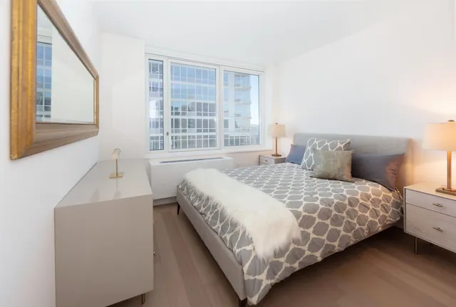 a bedroom with a bed and a large window