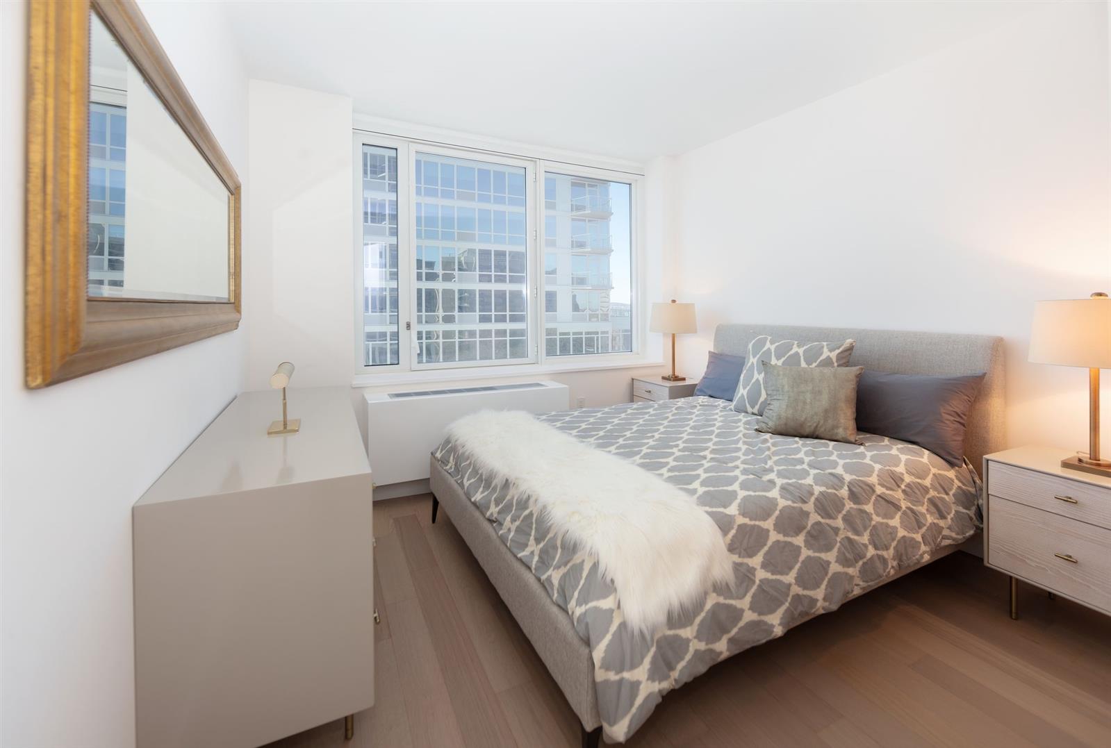 1 Ocean Drive, Unit E22D Brooklyn, NY 11224 - Photo 2 of 10 a bedroom with a bed and a large window