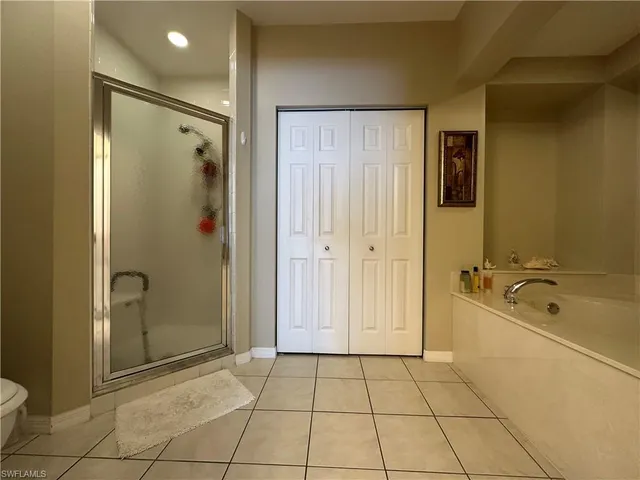 a spacious bathroom with a tub shower and checkered floor