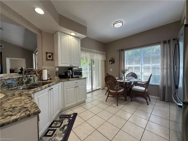 a kitchen with granite countertop a sink cabinets and stainless steel appliances