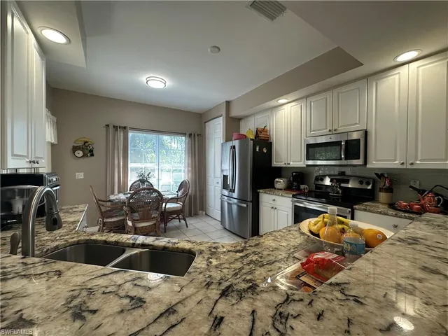 a kitchen with sink refrigerator and microwave
