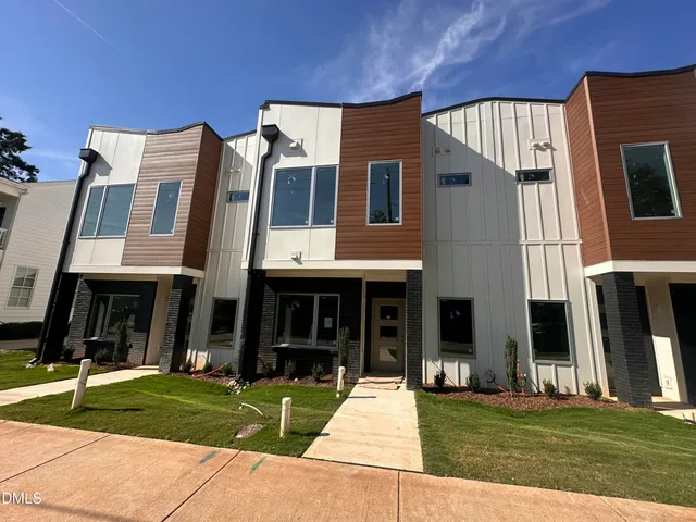 a view of a brick house with a yard in front of it