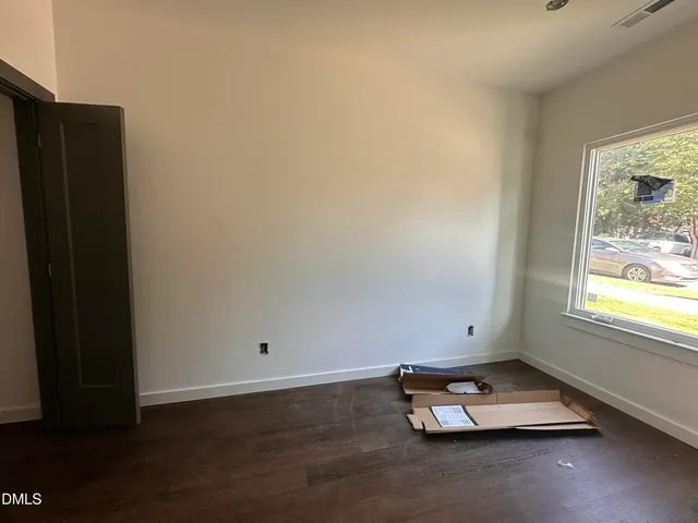 an empty room with wooden floor and window