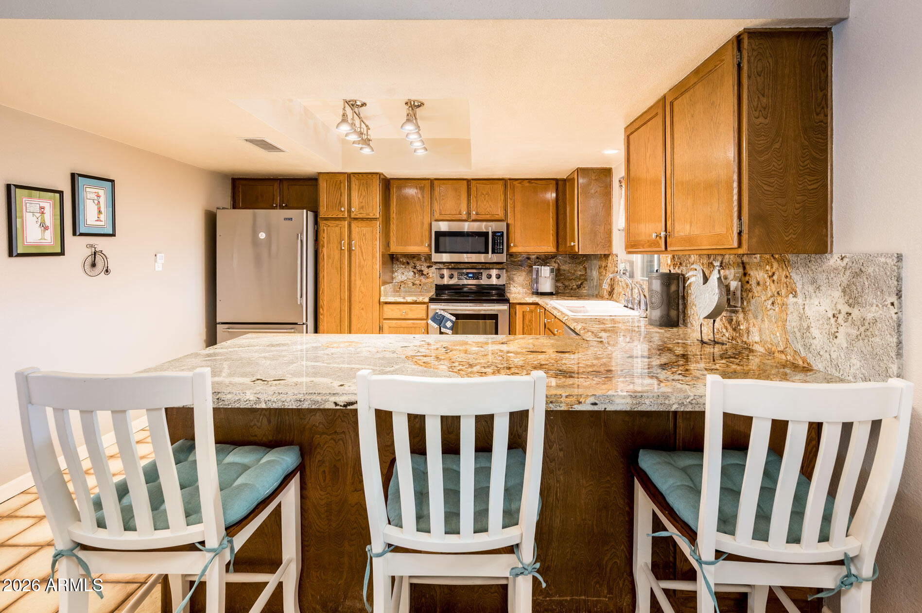 4730 West Piedmont Road Laveen, AZ 85339 - Photo 11 of 65 a kitchen with granite countertop kitchen island stainless steel appliances a dining table and chairs