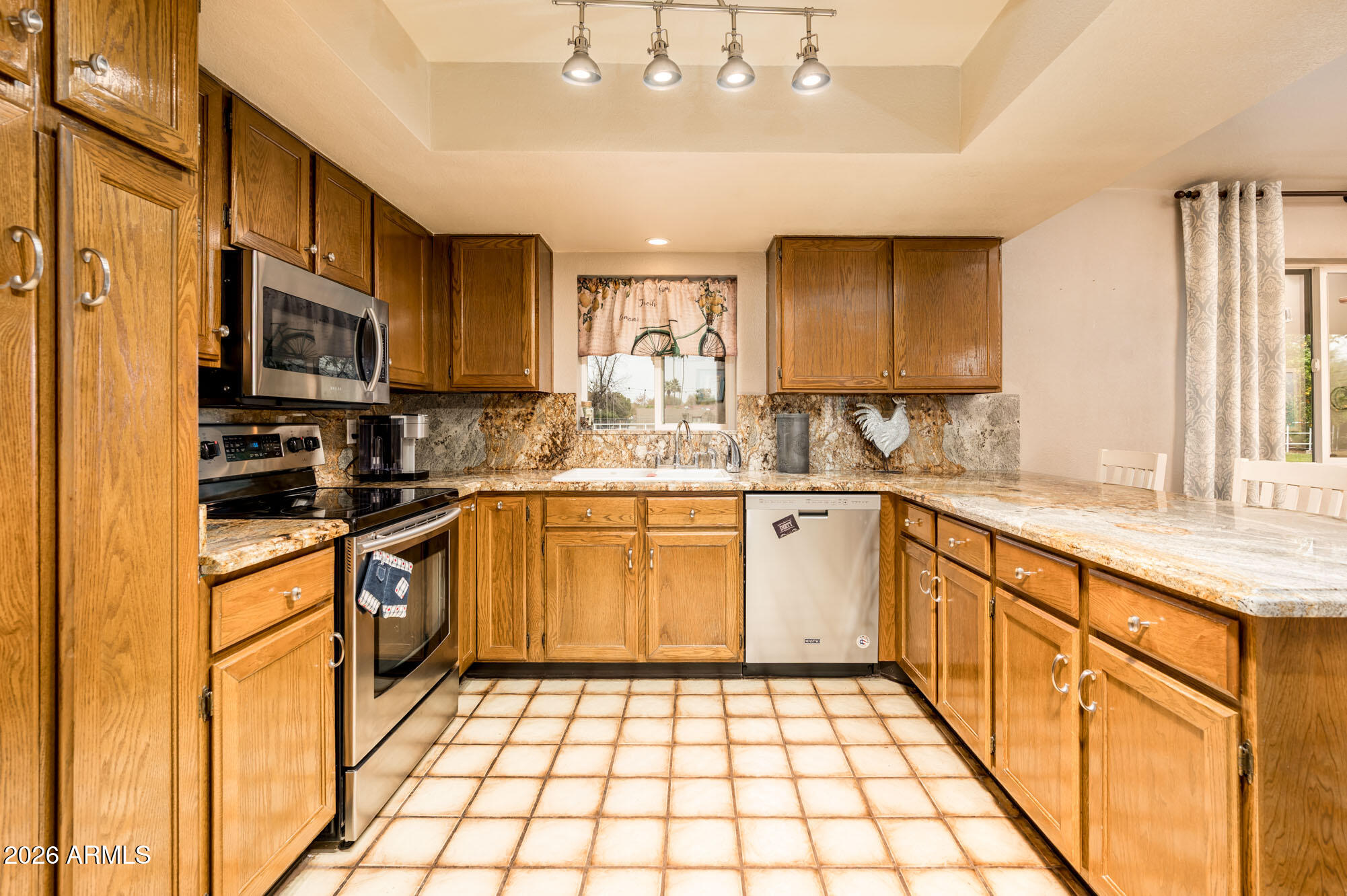 4730 West Piedmont Road Laveen, AZ 85339 - Photo 12 of 65 a kitchen with stainless steel appliances granite countertop a sink a stove a refrigerator cabinets and a window