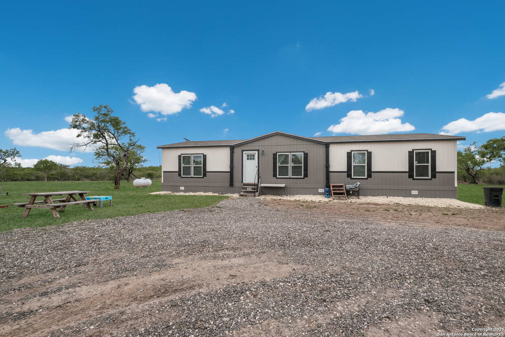 753 Pr Riley Lane Charlotte, TX 78011 - Photo 19 of 22 a front view of a house with a yard and a garage