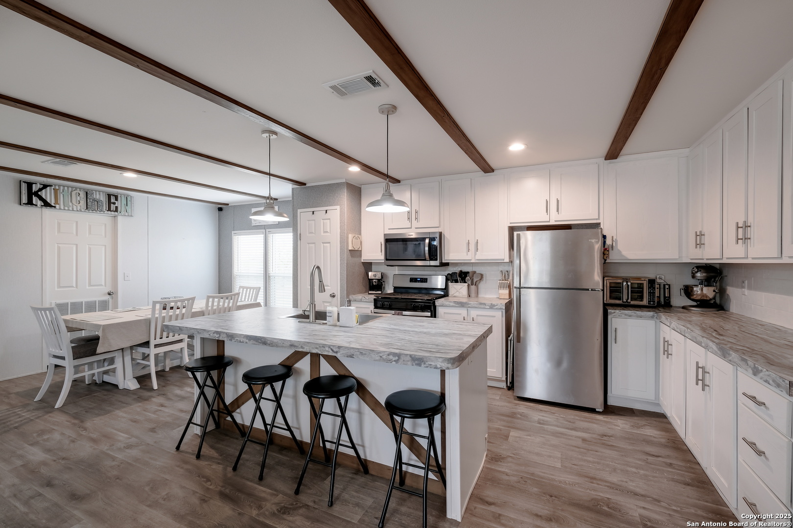 753 Pr Riley Lane Charlotte, TX 78011 - Photo 5 of 22 a kitchen with stainless steel appliances a refrigerator a stove a dining table and chairs