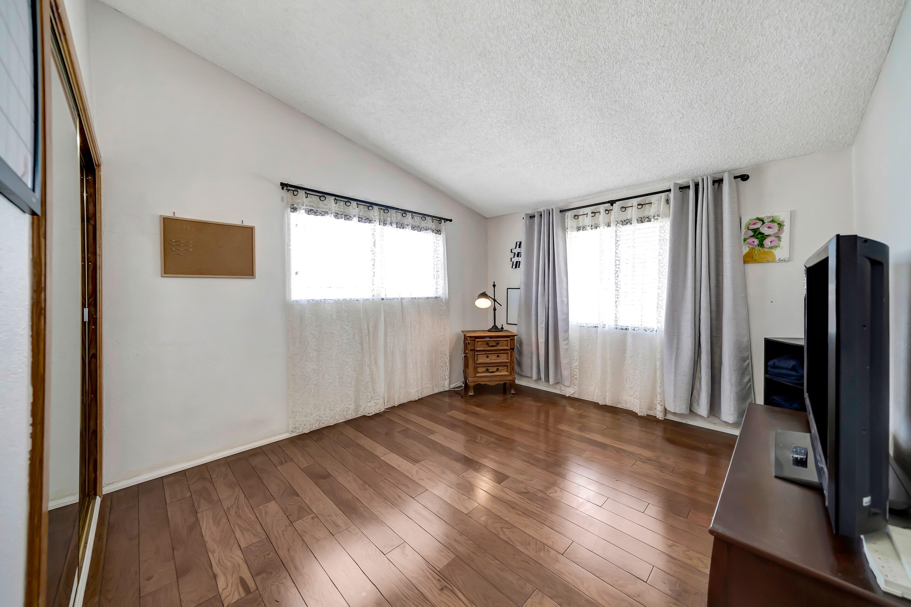 1617 Elizabeth Lake Road Palmdale, CA 93551 - Photo 21 of 45 a view of an empty room with a window and wooden floor