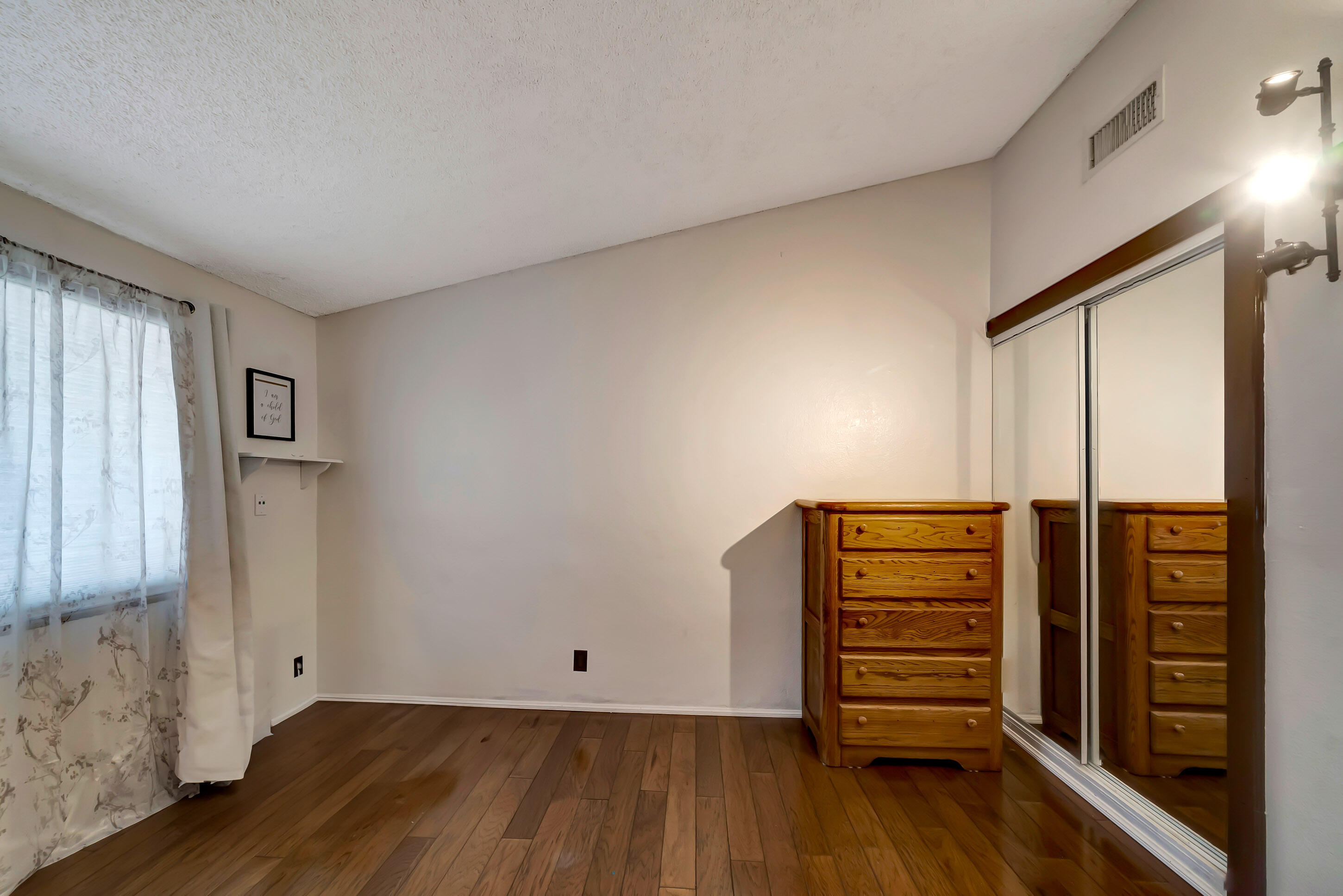 1617 Elizabeth Lake Road Palmdale, CA 93551 - Photo 28 of 45 an empty room with wooden floor and windows
