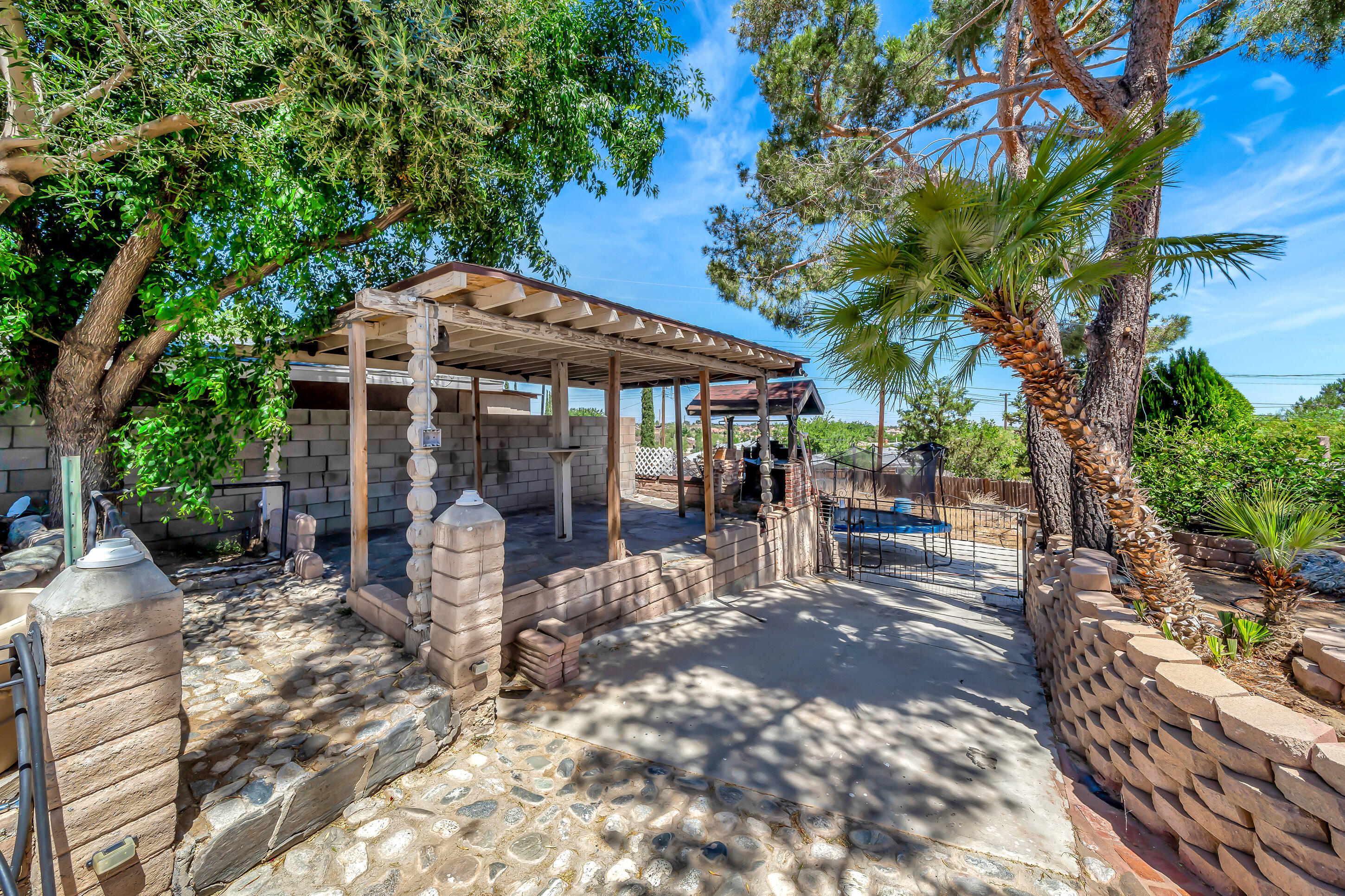 1617 Elizabeth Lake Road Palmdale, CA 93551 - Photo 33 of 45 a patio with a table and chairs under an umbrella
