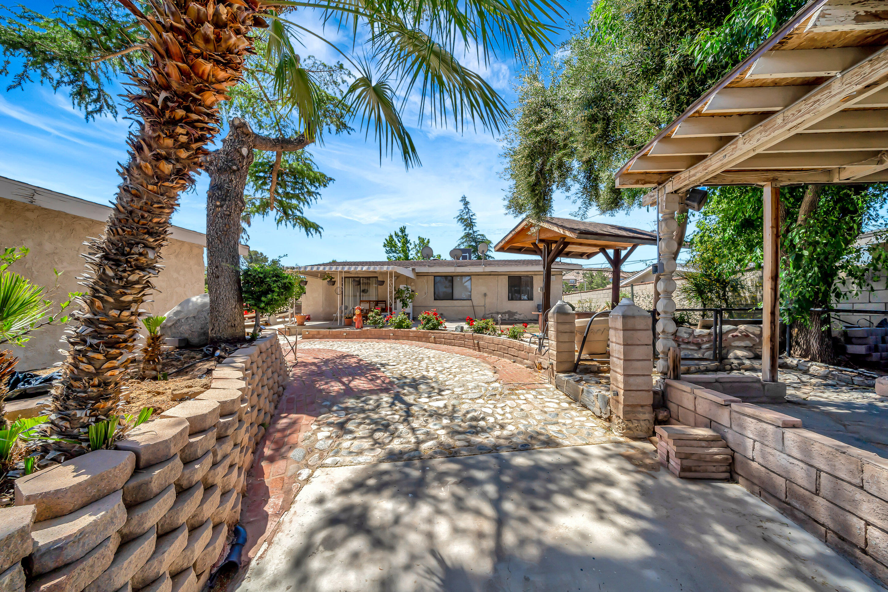 1617 Elizabeth Lake Road Palmdale, CA 93551 - Photo 37 of 45 a view of a patio with table and chairs under an umbrella with a barbeque