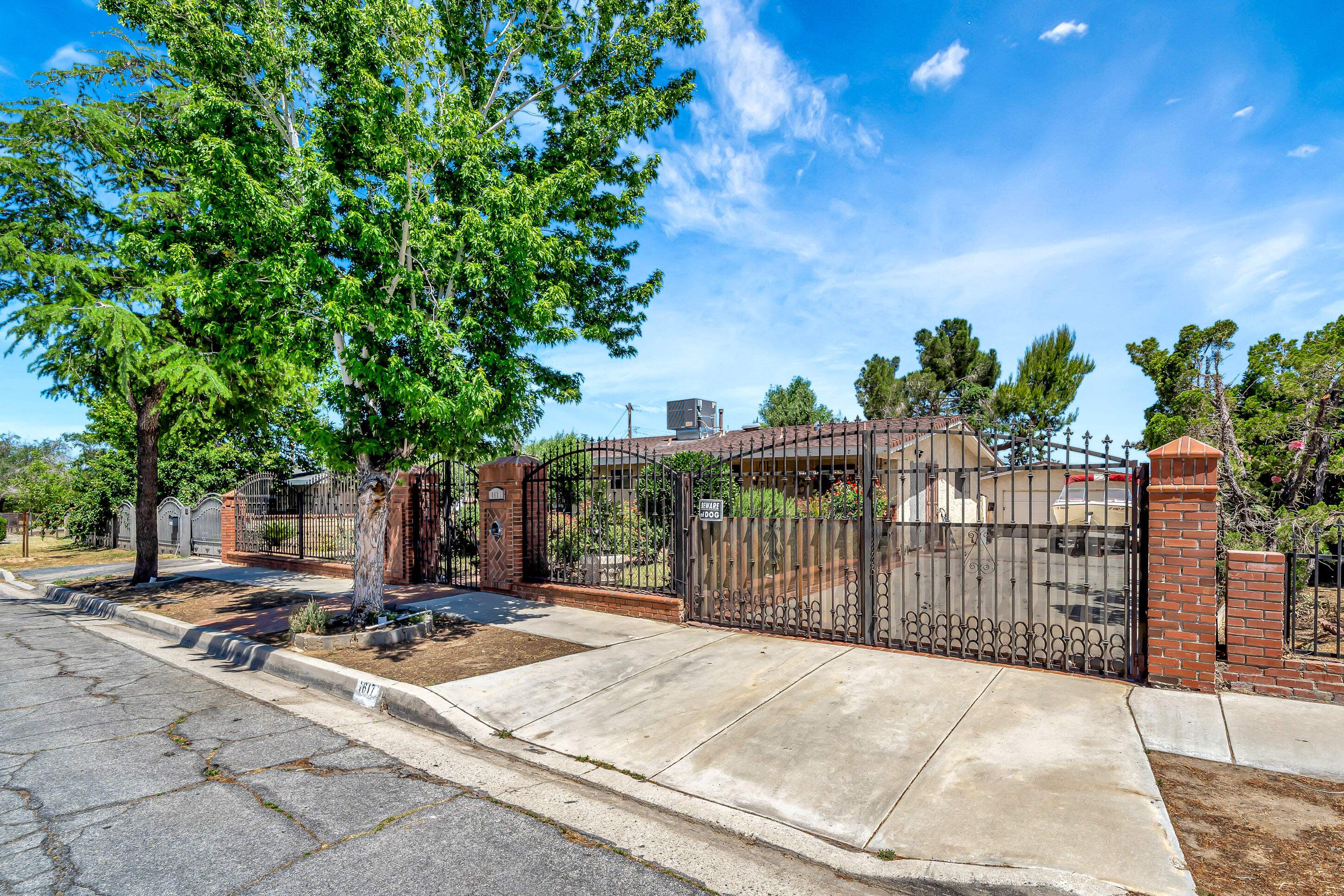 1617 Elizabeth Lake Road Palmdale, CA 93551 - Photo 6 of 45 a view of a backyard with brick wall and potted plants