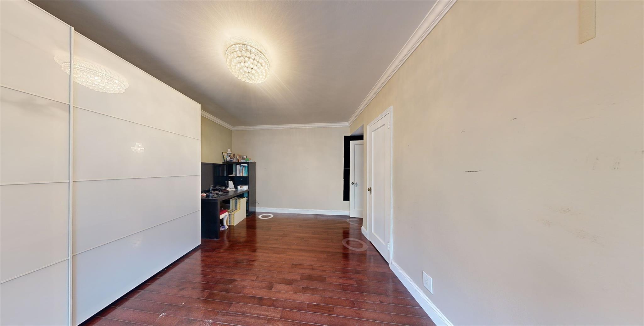 94-10 64th Road, Unit B6 Queens, NY 11374 - Photo 7 of 17 Hall featuring a chandelier, crown molding, dark wood-style flooring, and baseboards