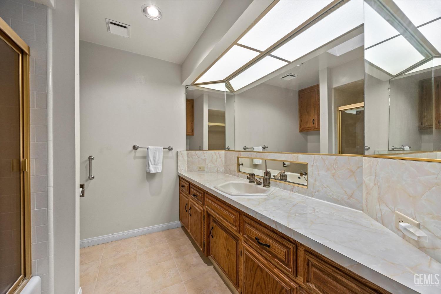 Undisclosed Address Bakersfield, CA 93309 - Photo 20 of 36 a spacious bathroom with a double vanity sink a mirror and a shower