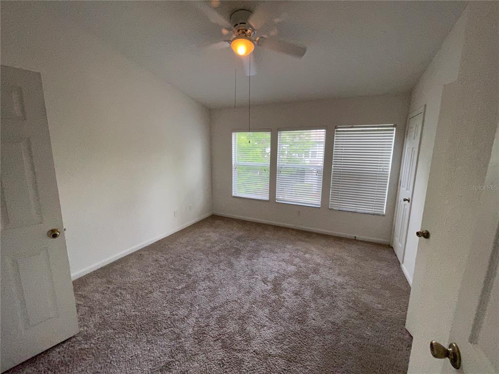 803 Shropshire Loop Sanford, FL 32771 - Photo 23 of 29 an empty room with windows and fan