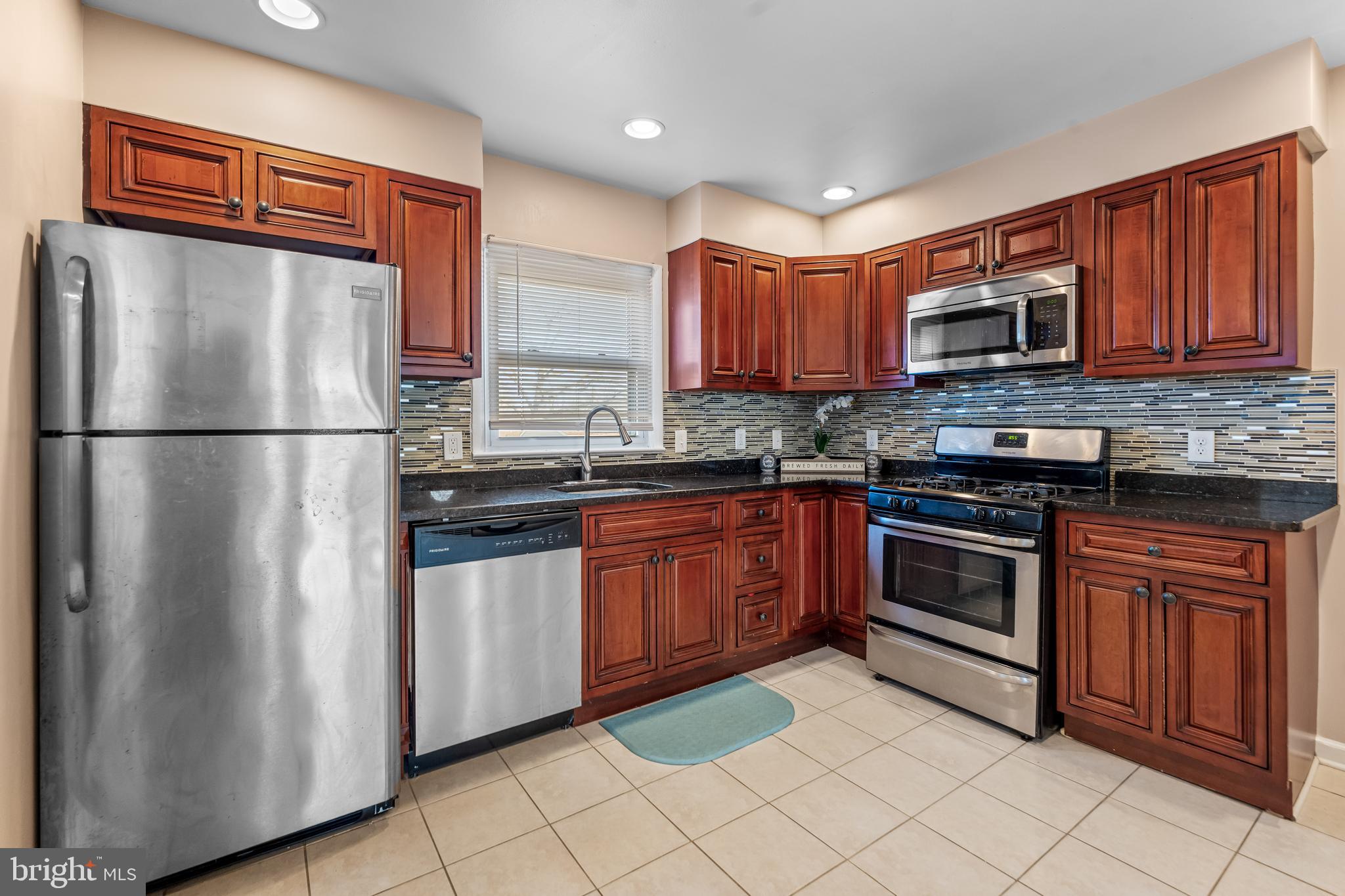 939 Clovis Avenue Capitol Heights, MD 20743 - Photo 8 of 25 a kitchen with granite countertop a refrigerator stove top oven and sink