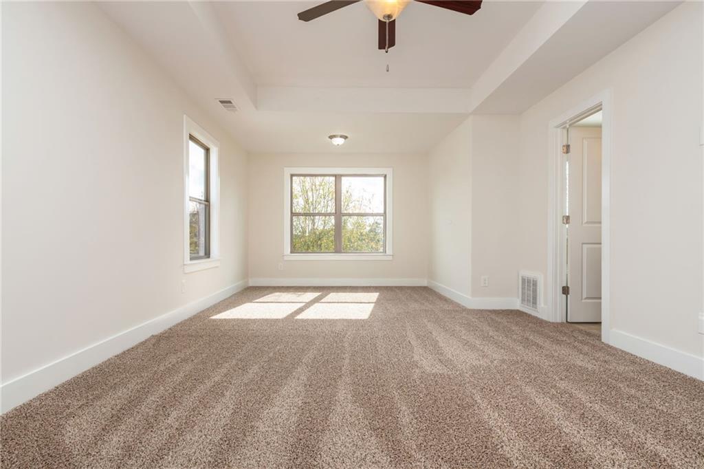 5914 High Hampton Lane Mableton, GA 30126 - Photo 20 of 32 an empty room with chandelier fan and windows