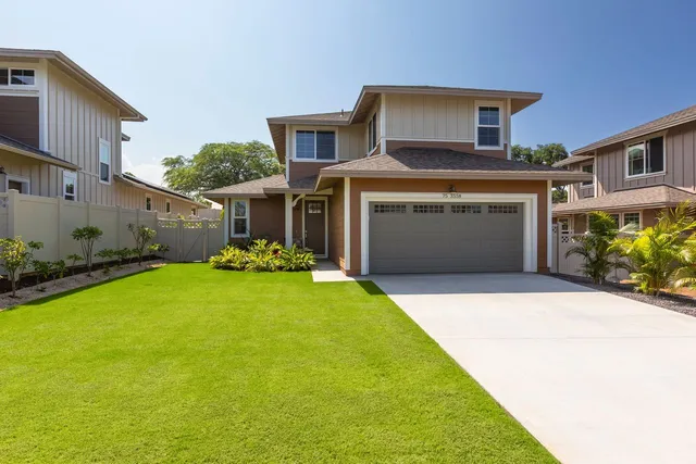 a front view of a house with a garden and yard