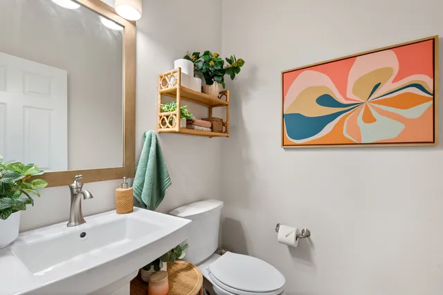 a bathroom with a sink mirror and toilet