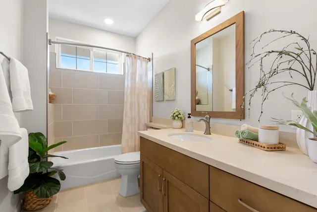 a bathroom with a double vanity sink toilet and shower