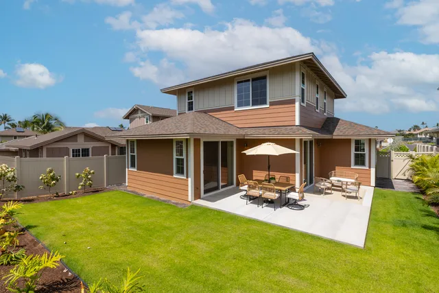 a view of a house with a yard patio and a small yard