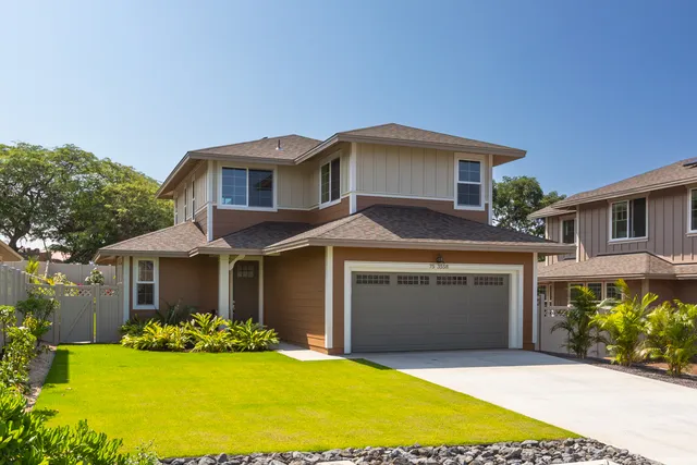 a front view of a house with a garden and yard