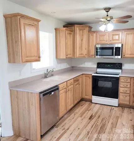 a kitchen with stainless steel appliances granite countertop a stove a sink and a microwave