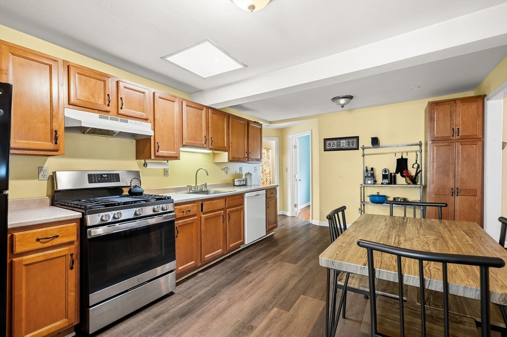 90 Loring Avenue Whitman, MA 02382 - Photo 8 of 22 a kitchen with granite countertop wooden floors and stainless steel appliances